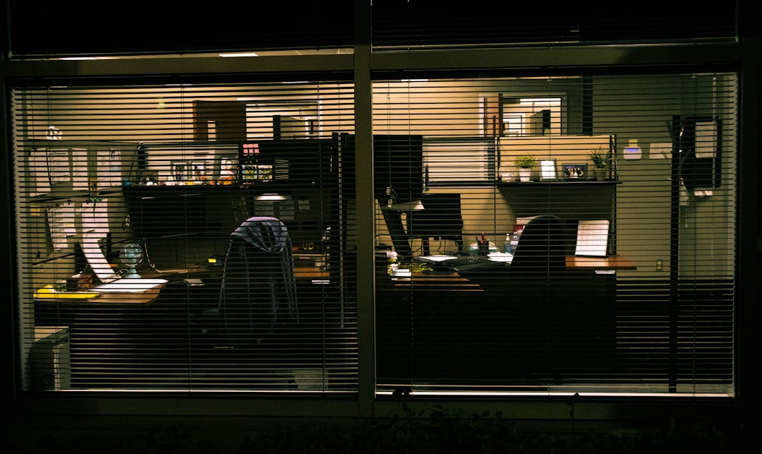 a view of a living room through blinds at night